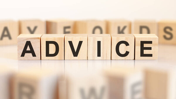 word advice is written on wooden cubes standing in a row. around the blocks with letters on a light background. can be used for business and financial concepts. selective focus
