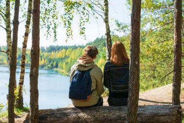 Romantik çift sonbahar parkında dinleniyor, güzel sonbahar havası var. Sevgililer birlikte vakit geçirir. Dikiz aynası. Sarı yapraklar, arka planda göl