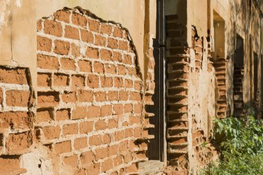 Bej Brickwall yontma sıva parçaları ile sıvalı. Kırmızı tuğla duvar hasar yüzeyi ile dokulu. Eski Grunge arka plan.