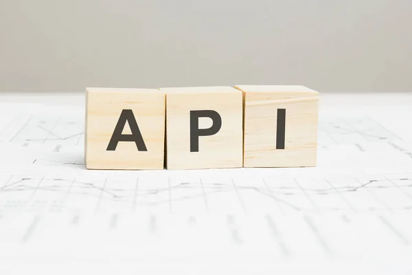 API wooden blocks word on grey background. API - application programming interface, information concepts — 图库照片