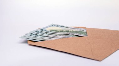 Beyaz arka planda kahverengi zarf içinde dolar parası. en üstteki görünüm.