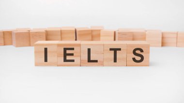 word IELTS is made of wooden building blocks lying on the table and on a light background. concept. IELTS - short for International English Language Testing System