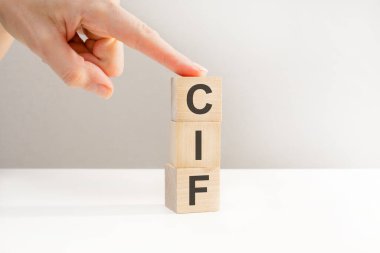 Küp tutan bir kadın, tahta küplerin üzerindeki CIF harfleri, iş konsepti. CIF - maliyet sigortası ve taşımacılığın kısaltması
