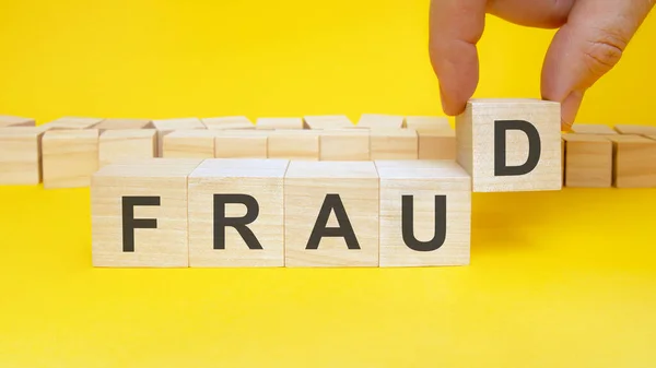 Man Making Word Fraud Wooden Cubes Yellow Table Closeup Space — Stock Photo, Image