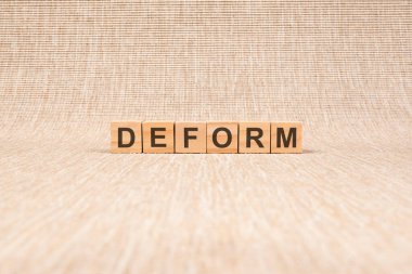 Tahta küplerle yazılmış deformasyon. Harflerle ahşap elementlerin topladığı kavramsal kelime. stok resmi, kahverengi arkaplan