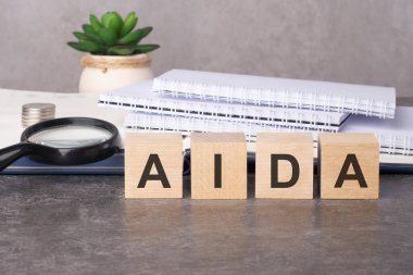 Siyah tablo üzerinde AIDA metni olan tahta bloklar