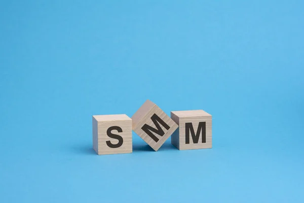 SMM-Text auf Holzklötzen, Geschäftskonzept, blauer Hintergrund — Stockfoto