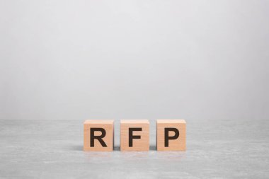 Parlak gri masanın üzerinde RFP harfleri olan üç tahta blok. İş konsepti. RFP - Teklif Talebi 'nin kısaltması