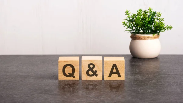 木製の立方体にQとAのアルファベットの文字 白い背景に緑の植物 QとA 質問と回答の略 — ストック写真
