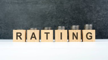 Değerlendirme sözcüğü, her küpün üzerinde farklı yükseklikteki bozuk paraların bulunduğu tahta küplere yazılmış metin, iş konsepti.