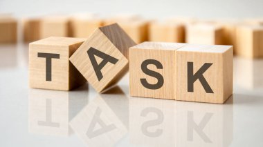 Gri bir masanın parlak yüzeyinde harf görevi yapan dört tahta blok. Küplerdeki yazılar yüzeyden yansıyor. ticari kavramsal.