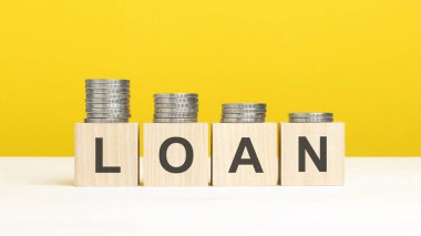 Kelime kredisi sarı arka plandaki tahta bloklar ve artan madeni para yığını