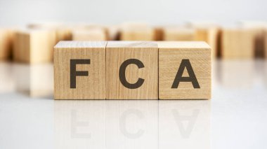 Tahta blok üzerine yazılmış FCA kelimesi, iş kavramı. FCA - Mali İdari İdarenin kısaltması