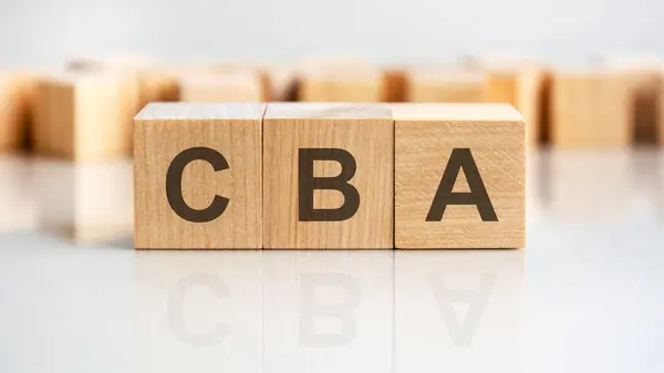 CBA word written on wood block, business concept. CBA - short for Cost Benefit Analysis