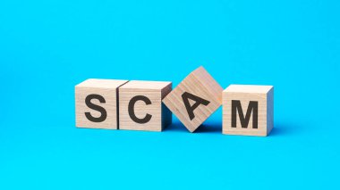 Açık mavi arkaplandaki tahta küplerden SCAM mesajı. finansal kavram