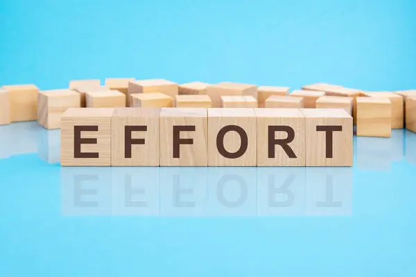 word EFFORT made with wood building blocks, blue background, business concept