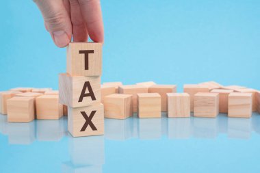 T harfiyle yukarı doğru yükselen ahşap küp bloğu. Vergi metni. finans, yönetim, ekonomi, iş kavramı.