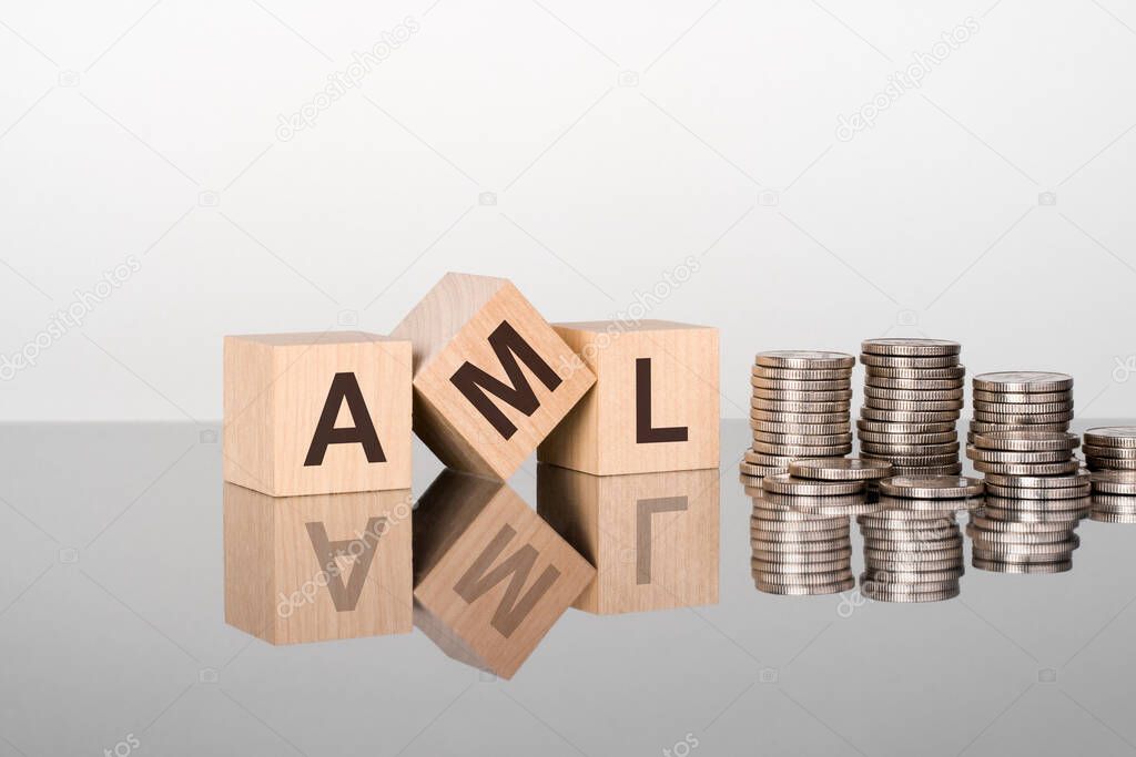 AML - Service Level Agreement - text is made up of letters on wooden cubes lying on a mirror surface, gray background. stacks with coins. inscription is reflected from the surface. selective focus.