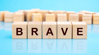 Mavi bir masanın parlak yüzeyinde cesur harflerle dört tahta blok. Küplerdeki yazılar yüzeyden yansıyor. ticari kavramsal.