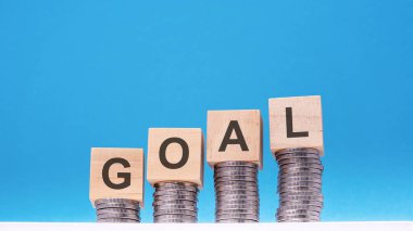 Metin hedefli tahta bloklar bozuk paralar, mavi arkaplan, iş konsepti