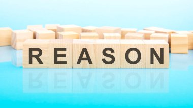 Ahşap yapı taşlarından yapılmış bir kelime. Metin siyah harflerle yazılır ve masanın ayna yüzeyine yansıtılır, mavi arkaplan, iş konsepti