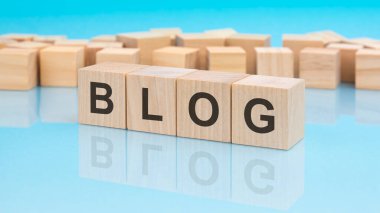 Tahta küplerle ilgili haber bloğu. mavi arka plan. Küplerdeki yazılar yüzeyden yansıyor. iş kavramı.