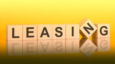 Tahta bloğa yazılmış bir kelime. Sarı arka plan. İş konsepti. Küplerdeki yazıtlar masanın yüzeyinden yansıyor. bir renk gradyanı kullanılıyor