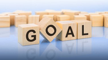 Mavi arkaplanın parlak yüzeyinde dört tahta blok var. Küplerdeki yazılar yüzeyden yansıyor. iş kavramı.