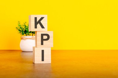 KPI - tahta küpler üzerine metin, sarı arkaplan