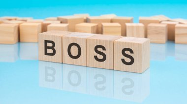 Sözcük patronu tahta küplerde. mavi arka plan. Küplerdeki yazılar yüzeyden yansıyor. iş kavramı.