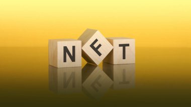 Sarı arka planda NFT yazılı tahta bloklar. soru ve cevap kavramı