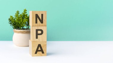 npa - word from wooden blocks with letters. business concept on green background. copy space available. npa acronym - non performing assets clipart