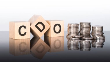 cdo - metin, ayna yüzeyinde duran tahta küplerdeki harflerden oluşur, gri arkaplan. Bozuk paralarla dolu desteler. Yazı yüzeyden yansıtılır..