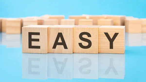 Word Easy Wooden Cubes Blue Background Inscription Cubes Reflected Surface — Stock Photo, Image