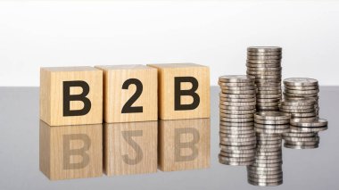 B2B 'de. Tahta küpler. Siyah arka planda bloklar var. Bozuk paralarla dolu desteler. Küplerdeki yazıtlar masanın yüzeyinden yansıyor. Seçici odaklanma. b2b - İş İşe