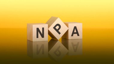 wooden blocks with text NPA on yellow background. question and answer concept. npa - short for Non Performing Assets clipart