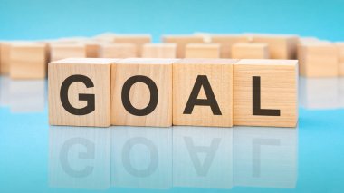 Mavi arka planda tahta küplere hedef kelime. Küplerdeki yazılar yüzeyden yansıyor. iş kavramı
