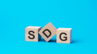 Tahta bloklar üzerine sdg metin, finansal iş konsepti, mavi arka plan. sdg - sürdürülebilir kalkınma hedeflerinin kısaltılmışı