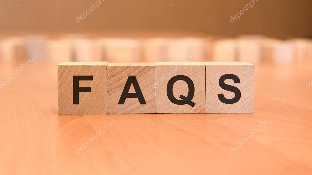 Wooden blocks with word FAQS on yellow background. frequently asked question concept. wooden background