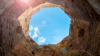 Kuledeki bulutların tuğla kule manzarası. Kule 'nin altından mavi gökyüzü. Güçlendirilmiş eski bir kalenin kalıntıları.