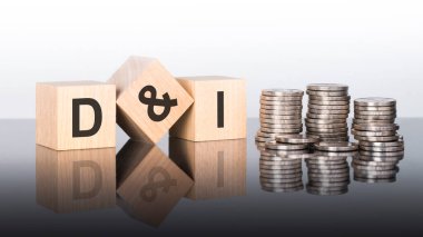 D ve ben - metin, ayna yüzeyinde duran tahta küplerdeki harflerden oluşur, gri arkaplan. Bozuk paralarla dolu desteler. Yazı yüzeyden yansıtılır. d ve i - Çeşitliliğin kısaltılmışı