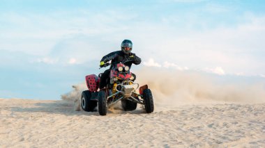 Atv 'in kum ocağında serbestçe dolaşması, ekstrem spor. mavi gökyüzü arkaplanı