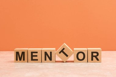 Ahşap bir sehpada, kahverengi arka planda akıl hocası metni.