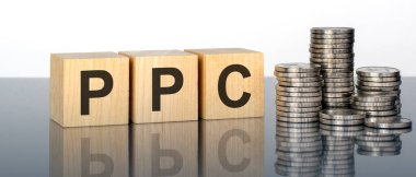 PPC - metin, ayna yüzeyinde duran tahta küplerdeki beyaz arkaplandaki harflerden oluşur. Bozuk paralarla dolu desteler. Yazı yüzeyden yansıtılır. PPC - Tıklama başına Ödeme 'nin kısaltması