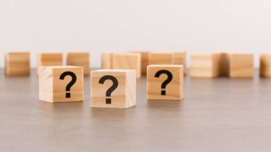 Tahta masada soru işareti olan üç tahta blok, yakın plan. Metin için boşluk. tahta arkaplan