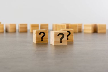 Tahta masada soru işareti olan üç tahta blok, yakın plan. Metin için boşluk. tahta arkaplan