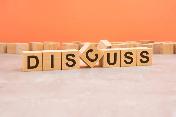 word discuss made with wood blocks. text is written in black letters, light background, business concept