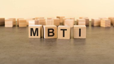 Yüzey masasının üzerinde MBTI harfleri olan dört tahta blok. MBTI - Myers-Briggs Tip Göstergesi.
