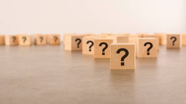 Pek çok tahta küpün önünde soru işaretleri var. Birçok soru ortaya çıkıyor. bela ve karmaşa