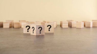 Tahta gri masada soru işaretleri olan üç tahta blok, yakın plan. Metin için boşluk. tahta arkaplan